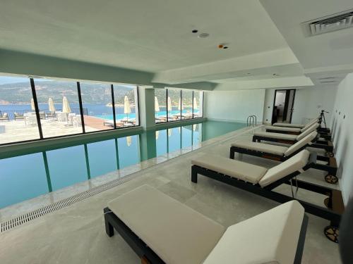 a large room with a swimming pool and some chairs at Lures Hotel in Kalkan