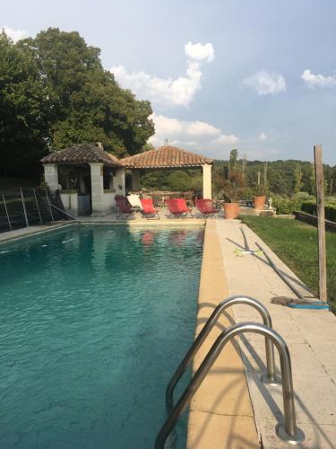 a swimming pool with chairs and a house at Campagne Valmont in Aix-en-Provence