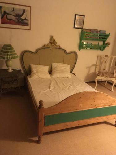 łóżko z drewnianą ramą w sypialni w obiekcie Campagne Valmont w Aix-en-Provence