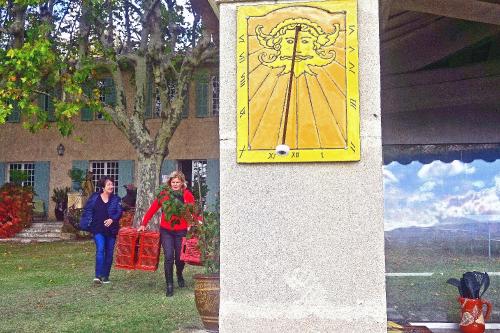 two women walking in front of a building with a yellow clock at Campagne Valmont in Aix-en-Provence