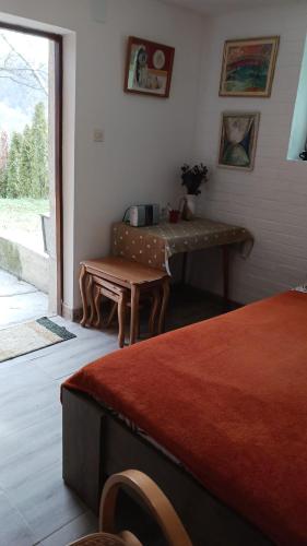 a room with a table and a bench next to a window at "Kod dva kestena"Warm and cozy house with lake view sauna in Međuvršje