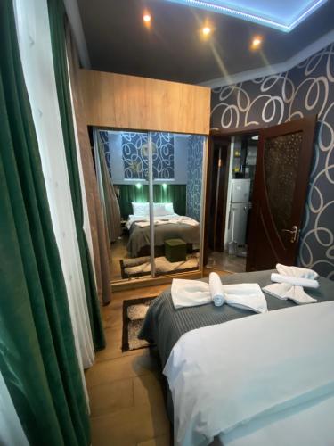 1 dormitorio con 2 camas y un espejo grande en Dea Apartments, en Batumi