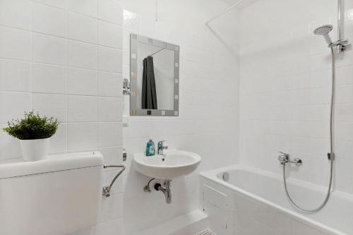 y baño blanco con lavabo y bañera. en Apartment with balcony in Mörfelden-Walldorf, en Mörfelden-Walldorf