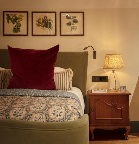 a bedroom with a bed and a table with a lamp at The Leicester Arms Country Inn in Penshurst