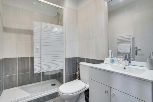 a white bathroom with a toilet and a sink at 808 Chic Suite - Superb Apartment in Bagnolet