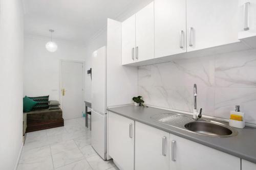 a kitchen with white cabinets and a sink at Un descanso 2-1 in Maspalomas
