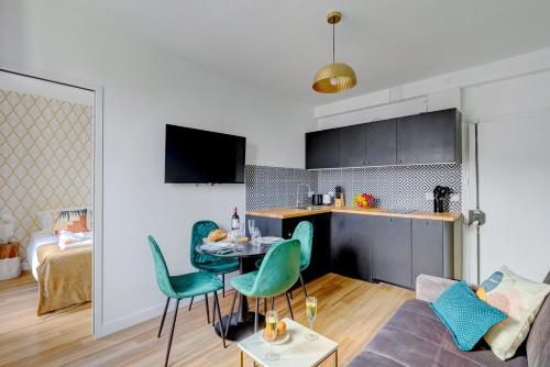 eine Küche und ein Wohnzimmer mit einem Tisch und Stühlen in der Unterkunft 870 Suite Trefle - Superb apartment in Montreuil