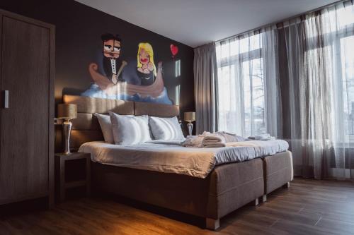 a bedroom with a large bed with a painting on the wall at Tres Boutique Hotel in Gorinchem