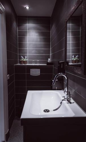 a bathroom with a white sink and a mirror at Tres Boutique Hotel in Gorinchem