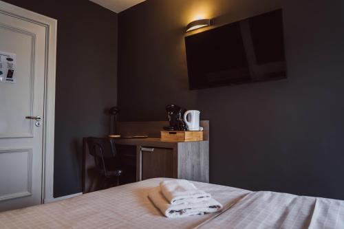 a bedroom with a bed with two towels on it at Tres Boutique Hotel in Gorinchem