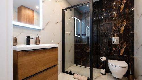 a bathroom with a shower and a toilet at Apartamenty Sun & Snow Poniwiec in Ustroń