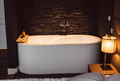 una vasca da bagno in una camera con parete in mattoni di Tres Boutique Hotel a Gorinchem