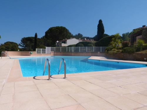 uma grande piscina com duas barras de metal ao redor em GASCOU - Golfe de St-Tropez - Mazet dans un domaine avec piscine et terrain de tennis em Cogolin