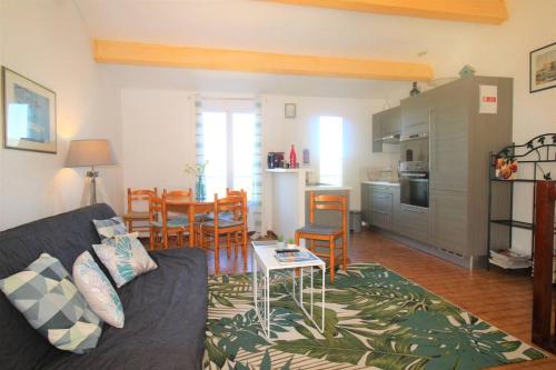 uma sala de estar e cozinha com um sofá e uma mesa em GASCOU - Golfe de St-Tropez - Mazet dans un domaine avec piscine et terrain de tennis em Cogolin