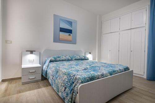 1 dormitorio con 1 cama con edredón azul en Agio Apartments Diamante - Bilocale, en Diamante