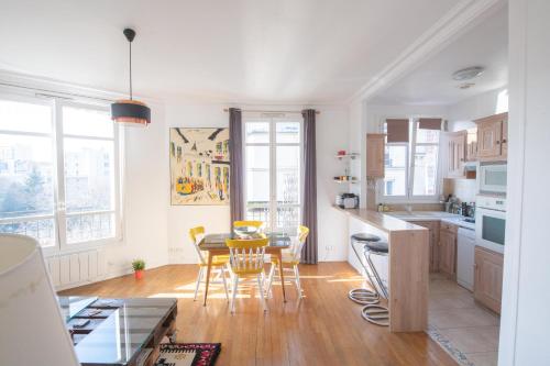 une cuisine et une salle à manger avec une table et des chaises dans l'établissement Cosy and very nice flat with open view on a parc, à Paris