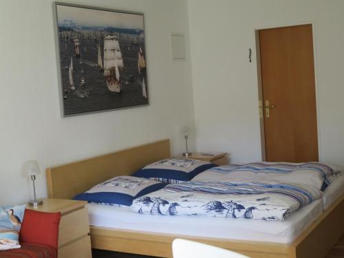 a bed in a room with a picture on the wall at Schönes Appartement in ruhiger Lage in Kiel