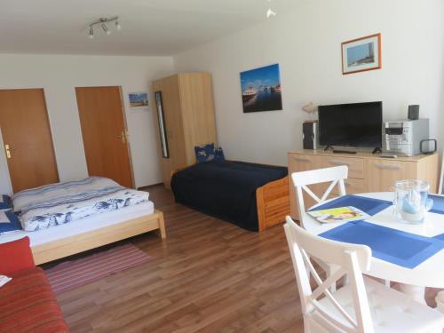 a small living room with a bed and a table at Schönes Appartement in ruhiger Lage in Kiel