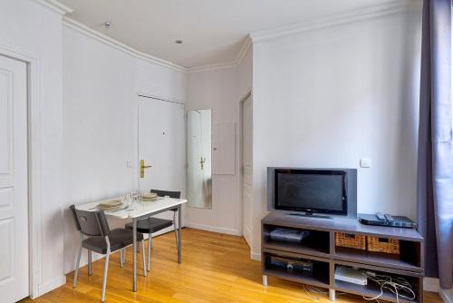 uma sala de estar com uma mesa e uma televisão em 316 Suite BIOT 6 - Superb apartment in Paris em Paris