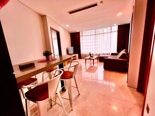 Zimmer mit einem Tisch und Stühlen sowie einem Wohnzimmer in der Unterkunft Vortex klcc in Kuala Lumpur