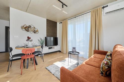 een woonkamer met een bank en een tafel bij Fresh & Stylish Apartments in Poznań with Parking & Balcony by Renters in Poznań