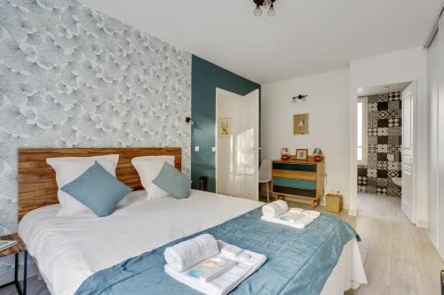 una camera da letto con un grande letto bianco con accenti blu di 215 Suite Esprit Nature - Superb apartment a Parigi