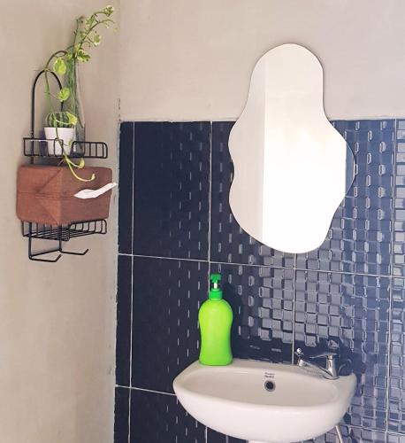 a bathroom with a sink with a light above it at Villa Pondok Kelapa Batu in Batu
