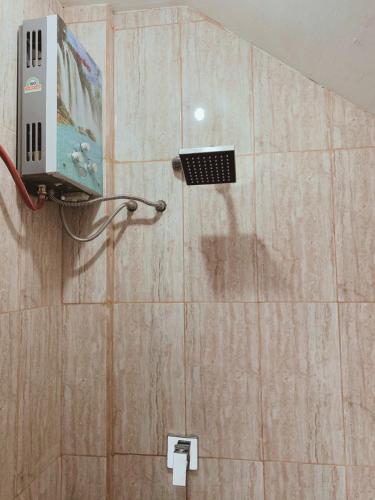 a shower in a bathroom with a wall at Villa Pondok Kelapa Batu in Batu