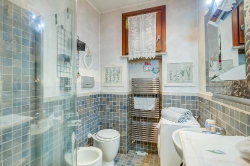 ein blau gefliestes Bad mit WC und Waschbecken in der Unterkunft Viviana Apartment - Happy Rentals in  Monvalle 