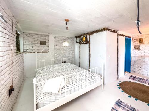a white bed in a room with a brick wall at Villa Lisinj apartments in Dapčevići