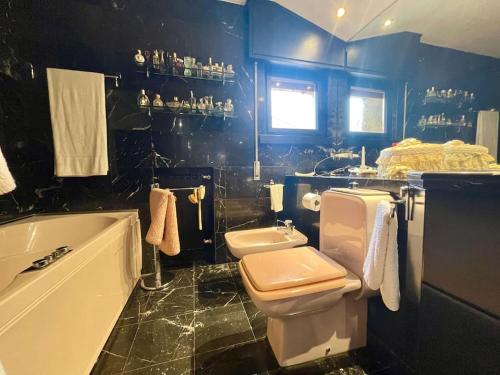 uma casa de banho com uma banheira, um WC e um lavatório. em Incantevole Villa con Giardino em Florença