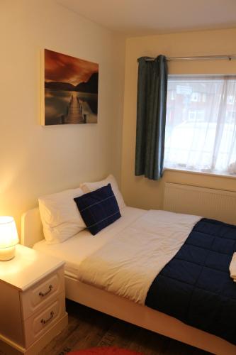 een slaapkamer met een bed en een raam bij EnSuite Room with private shower, walking distance to Harry Potter Studios in Leavesden Green