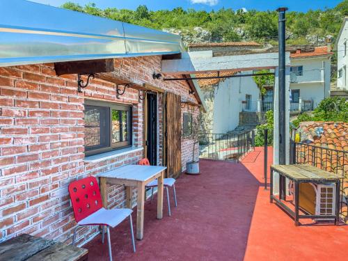 a patio with a table and chairs on a brick building at Villa Lisinj apartments in Dapčevići