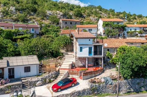 a red car parked in front of a house at Villa Lisinj apartments in Dapčevići
