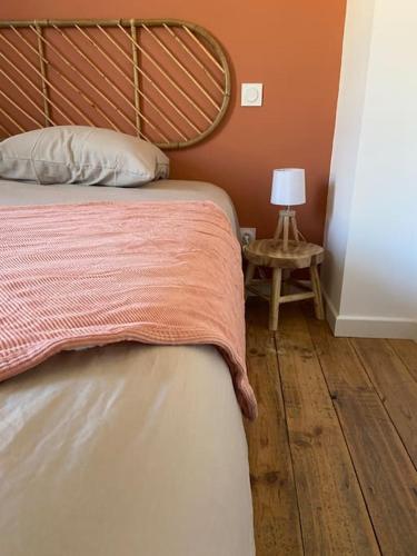 a bedroom with a bed and a table with a lamp at Le gîte du bonheur in Dalou