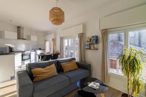 Una sala de estar con un sofá y una cocina. en L' Oriol à Chatel-Guyon, en Châtel-Guyon