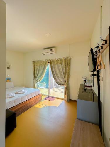 a bedroom with a large bed and a window at ชอว์ งาทอง รีสอร์ต Chor Ngar Thong Erawan Kanchanaburi in Kanchanaburi