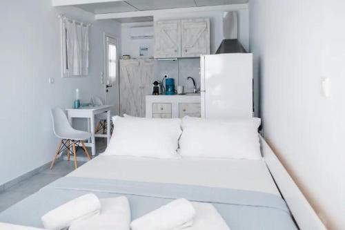 1 dormitorio blanco con 1 cama y cocina en Zacharias Seaside Studio Kimolos, en Kimolos