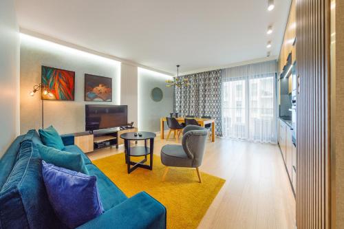 un soggiorno con divano blu e tavolo di Tomorrow Land : Nadmorze Premium a Danzica