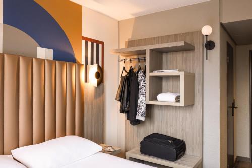 a bedroom with a bed and a wall with a rainbow at ibis Styles Saint-Quentin in Saint-Quentin