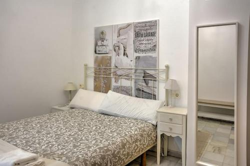 1 dormitorio con cama y espejo en Precioso piso residencial en Sevilla