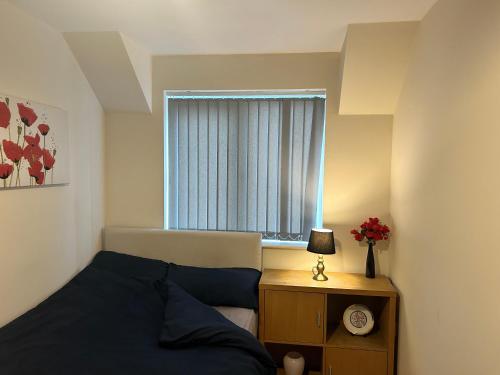 1 dormitorio con cama y ventana en 2-Bed spacious apartment - One Ensuite, en Warrington