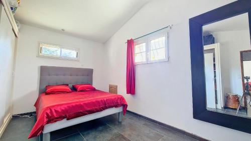 1 dormitorio con 1 cama con sábanas rojas y espejo en Maison proche Dentelles Ventoux et Avignon, en Sarrians