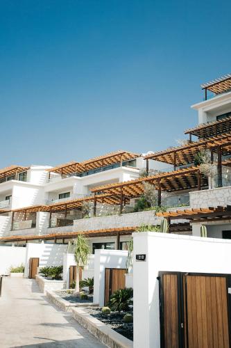a white building with wooden doors in front of it at Lures Hotel in Kalkan