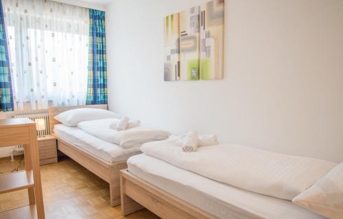 two beds in a room with a table and a mirror at Apartment Seeblick in Zell am See