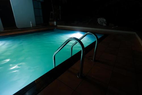 una piscina por la noche con una escalera en PADMA VILLAGE, en Thodupuzha