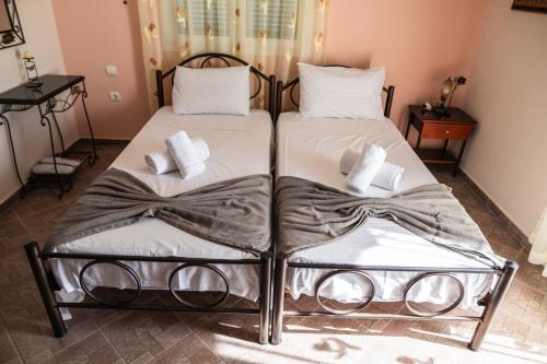 two beds in a room with white sheets and pillows at Pigeon House in Plataria