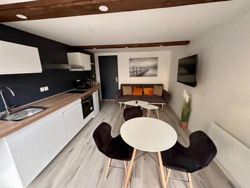 une cuisine et un salon avec une table et un canapé dans l'établissement Confortable appartement centre de Vichy, à Vichy