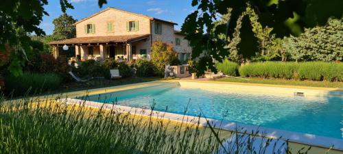 a house with a swimming pool in front of a house at Agriturismo Vellaneta in Cagli
