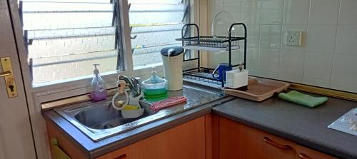 a kitchen counter with a sink and a window at ZNA Prop d Seri Bulan Resort,PD in Port Dickson